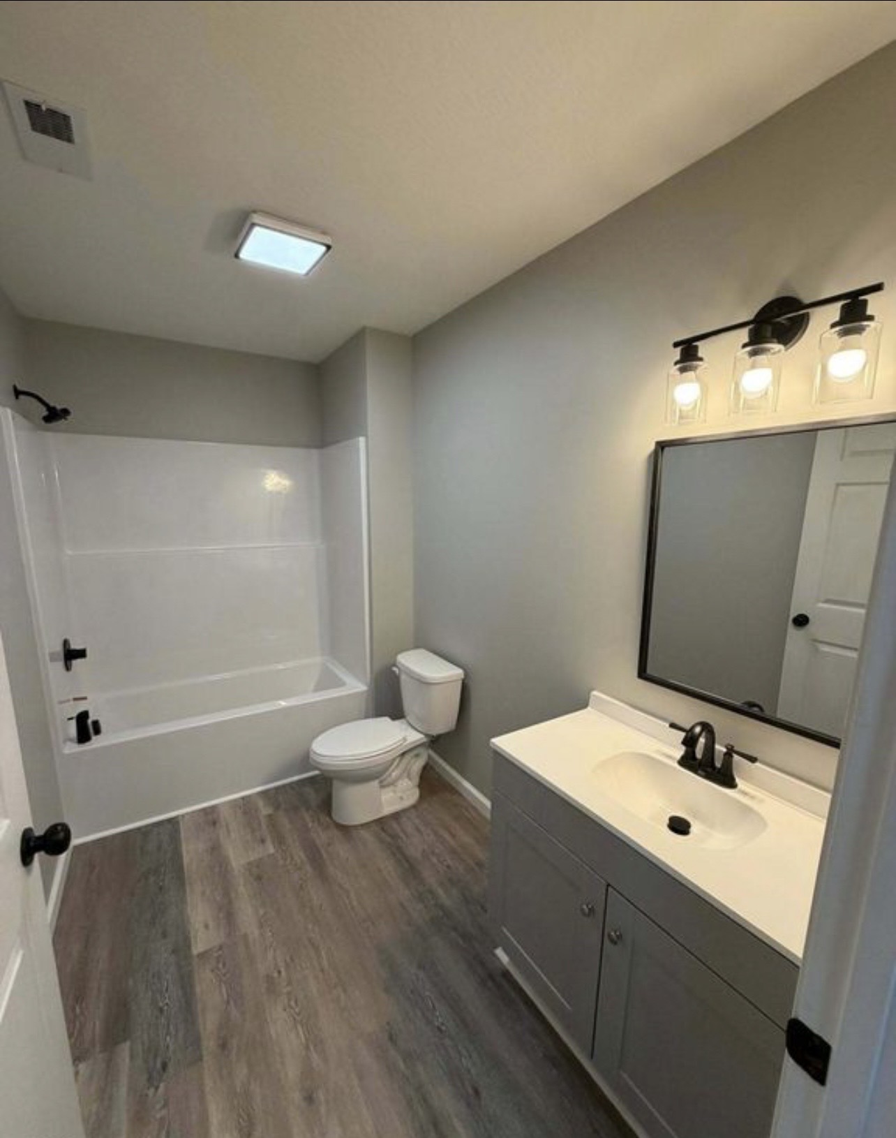 Bathroom with modern gray vanity and black fixtures